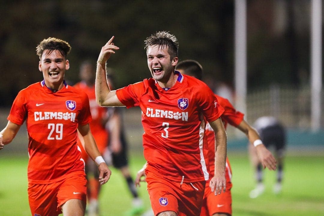 Adam Lundegard celebrando con la camiseta de Clemson junto a un compañero
