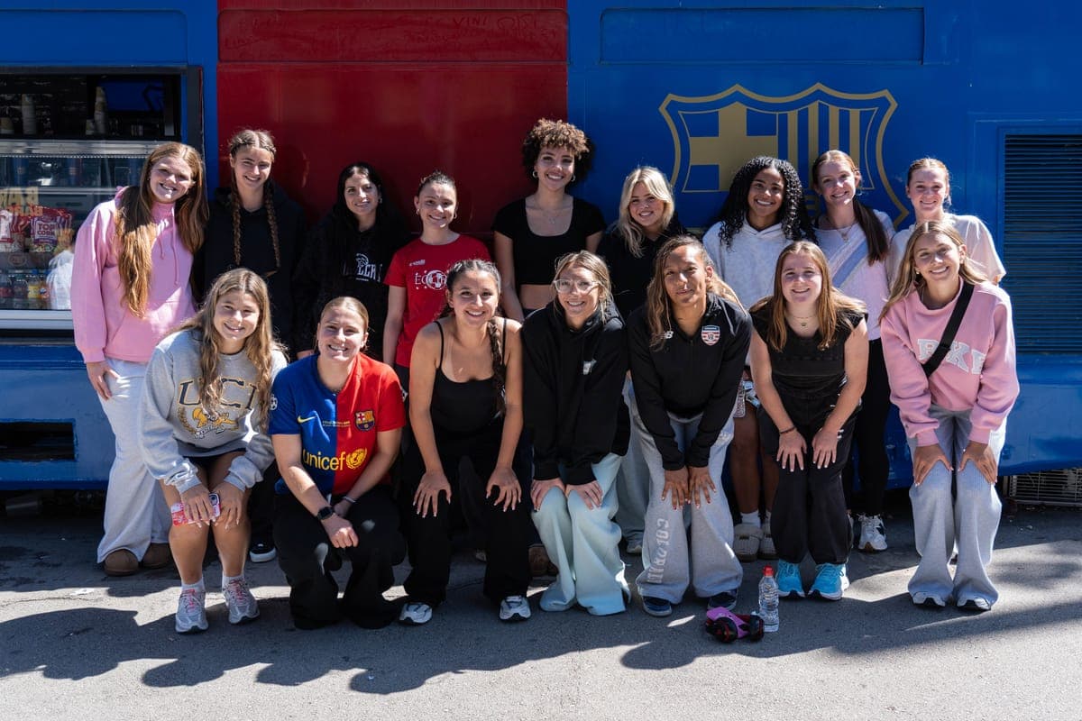 The group in front of a club crest on a visit in Barcelona