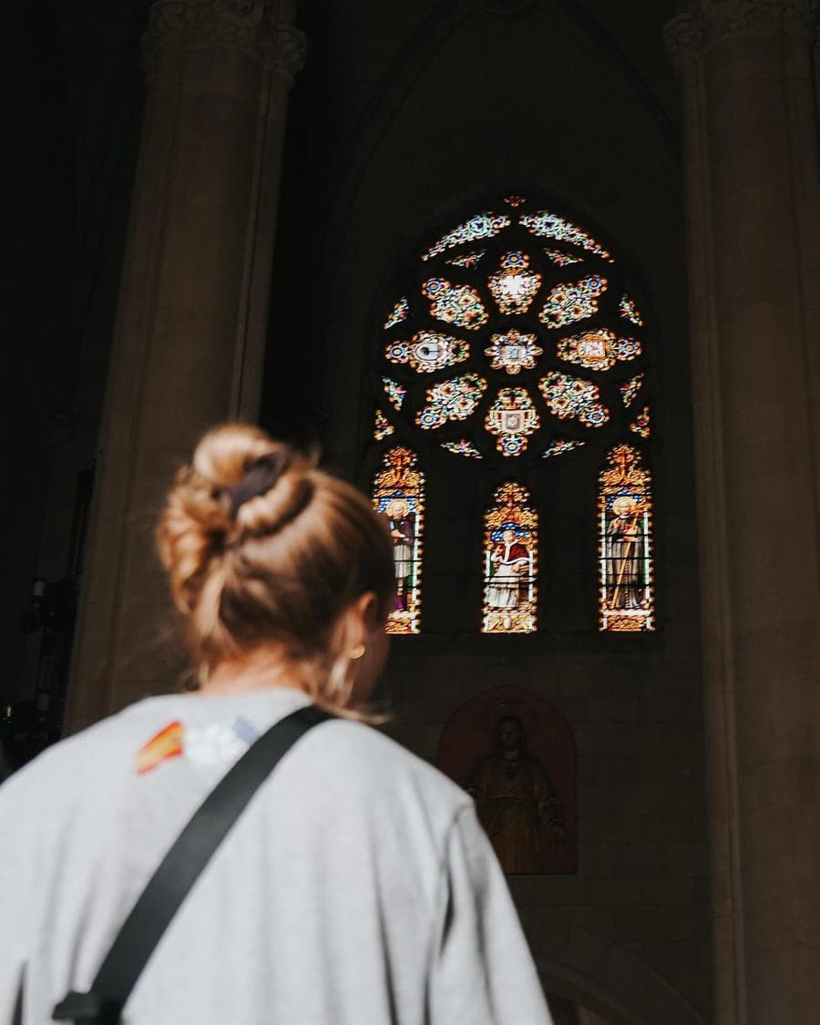 A player looking up at the stained glass inside a cathedral